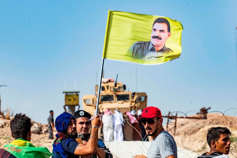 A Syrian Kurd waves a flag with the portrait of jailed Kurdish militant leader Abdullah Ocalan during a demonstration against Turkey. AFP