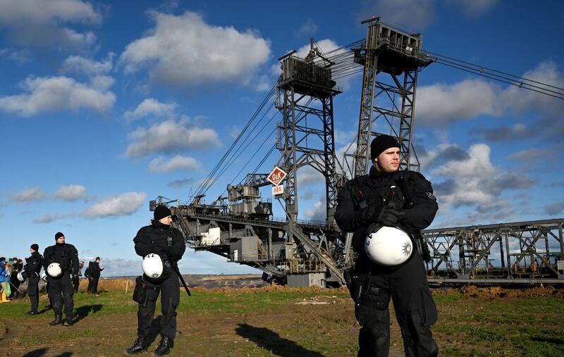 Police officers guard an excavator. AFP