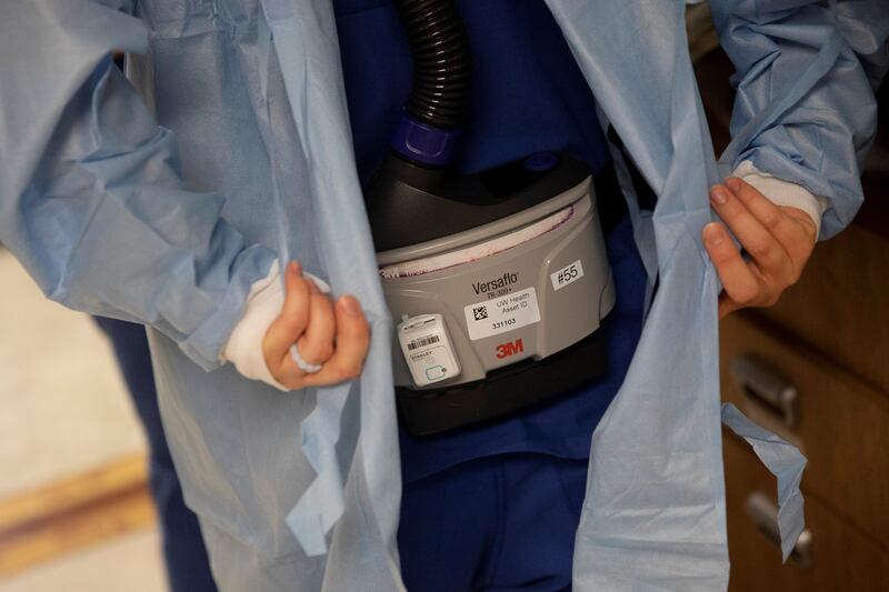 Nursing Assistant Brittany Digman wears a 3M Versaflo TR-300+ powered air purifying respirator as she prepares to enter the room of a Covid-19 patient being treated at UW Health University Hospital in Madison, Wisconsin. Reuters