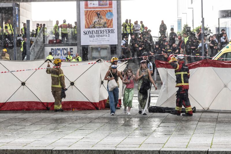 A woman is escorted out of the mall after the attack. AP