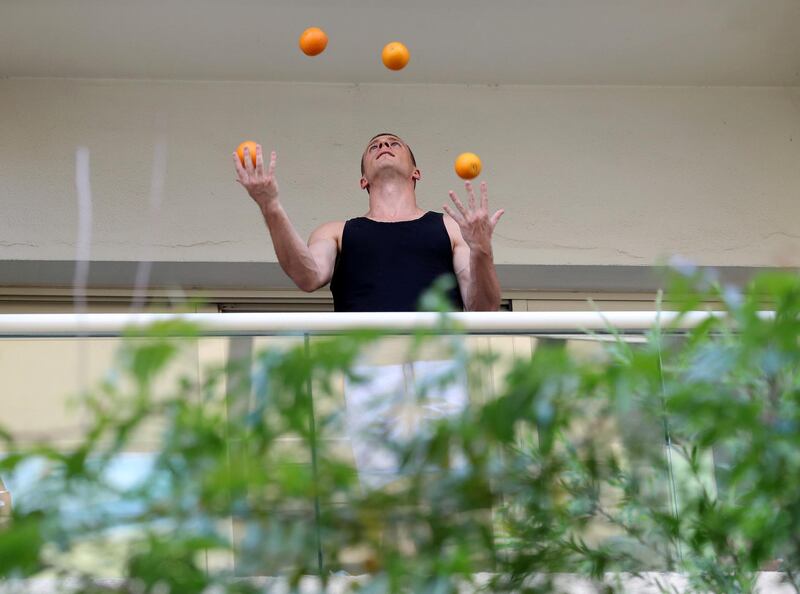Dubai, United Arab Emirates - Reporter: Rory Reynolds: Boki Prekovic, a Serbian accordion player keeping residents stuck at home entertained from his balcony. Another gentleman joins him by juggling. Thursday, March 19th, 2020. The Greens, Dubai. Chris Whiteoak / The National
