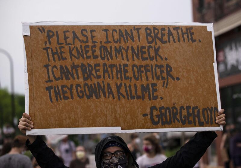 A protester holds a sign while demonstrating against the death of George Floyd outside the 3rd Precinct Police Precinct in Minneapolis, Minnesota.  AFP