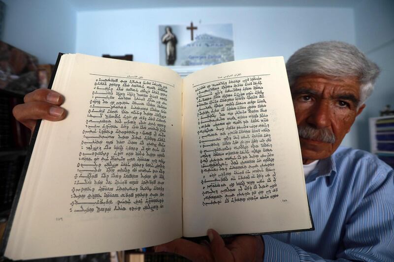 George Zaarour, a specialist in the Aramic language, shows a book written in the Aramic script in the SYrian mountain village of Maalula, in the Damascus region on May 13, 2019. Today, "80 percent of Maalula's inhabitants don't speak Aramaic, and the remaining 20 percent are over 60 years old," said an expert.
Etched out in the cliff face, and full of churches, convents, and monasteries, Maalula is considered a symbol of Christian presence in the Damascus region. 
 / AFP / LOUAI BESHARA

