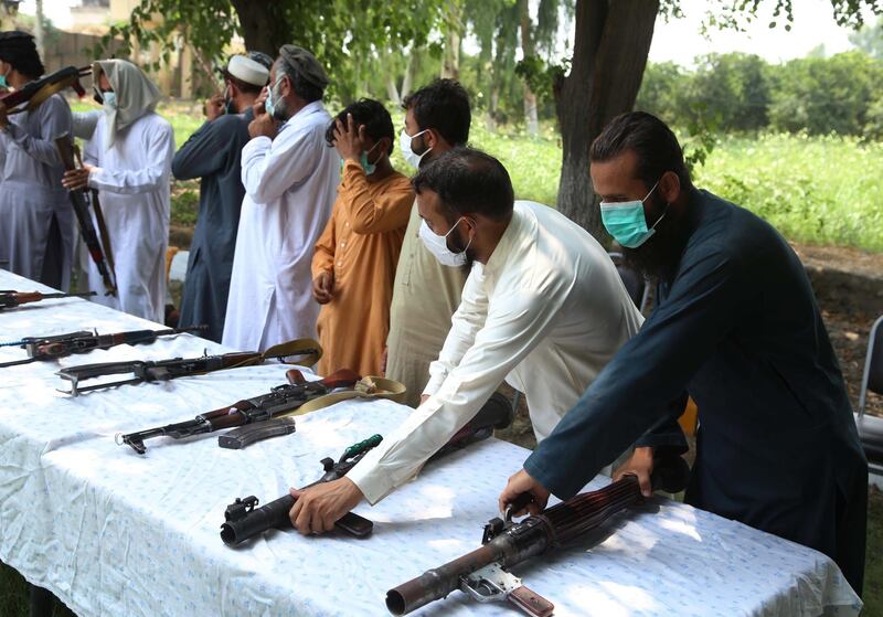 epa08568505 Former militants surrender their weapons during a reconciliation ceremony in Jalalabad, Afghanistan, 27 July 2020. A group of 14 former Taliban militants laid down their arms in Jalalabad and joined the peace process. On 29 February, US officials and Taliban representatives signed an agreement after months of negotiations in Qatar's capital that is aimed at ending the United States's longest war, fought in Afghanistan since 2001.  EPA/GUHLAMULLA HABIBI
