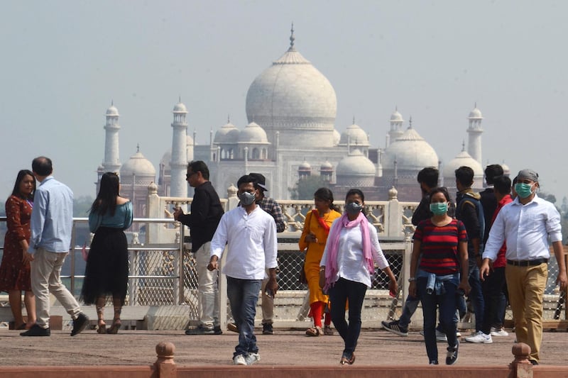 Tourists wear facemasks as a preventive measure against the spread of the COVID-19 coronavirus outbreak, near Taj Mahal in Agra on March 5, 2020. - More than 95,000 people have been infected and over 3,200 have died worldwide from the new coronavirus, which by on March 5 had reached some 80 countries and territories. (Photo by Pawan Sharma / AFP)