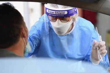 Health workers wearing overalls and protective masks perform swab tests in Rome on Monday. EPA
