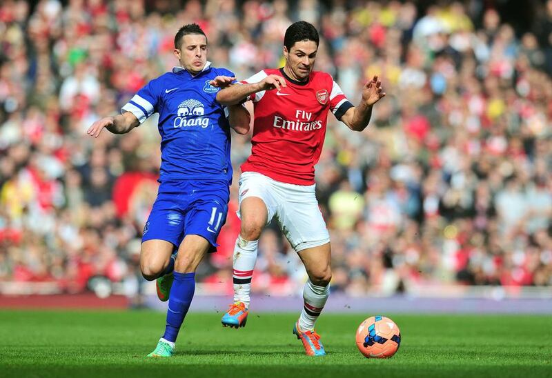 Arsenal's Spanish midfielder Mikel Arteta, right, tussles with Everton's Belgian striker Kevin Mirallas during the English FA Cup quarter-final at the Emirates Stadium in London on March 8, 2014. Glyn Kirk / AFP