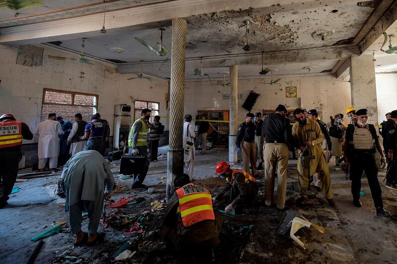 Security officials examine the site of a blast at a religious school in Peshawar. AFP