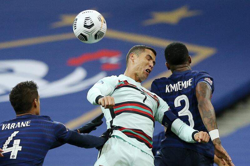 France players Raphael Varane, left, and Presnel Kimpembe fight for the ball with Cristiano Ronaldo of Portugal. EPA