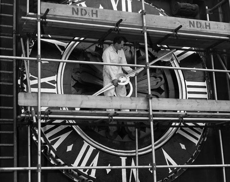 A worker positioning the single hand of the Ting-Tang Quarter Turret clock after it was removed for cleaning in 1960