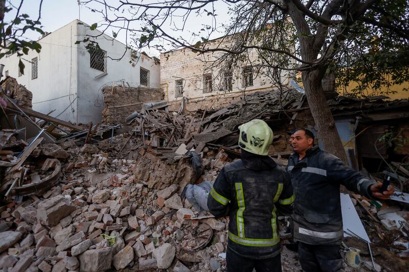 Rescuer workers at a building destroyed in an attack in Mykolaiv. Reuters