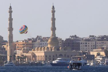 Tourists parasail in front of the Port Grand Mosque in the Egyptian Red Sea resort of Hurghada on August 25, 2020. Reuters
