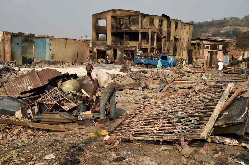 A man tries to salvage valuable from burnt shops after deadly ethnic clashes between the northern Fulani and southern Yoruba traders at Shasha Market in Ibadan, southwest Nigeria, on February 15, 2021. Nigerian President vowed to protect all religious and ethnic groups in the country after deadly clashes erupted between different communities at a market in the southwest over the weekend. Long-standing rivalry over access to land and resources between northern Fulani herders and southern Yoruba farmers are behind renewed ethnic tensions across the south. / AFP / PIUS UTOMI EKPEI
