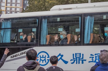 Members of World Health Organisation team sit in a bus as they leave the Jade Boutique hotel after the mandatory 14-day quarantine, in Wuhan, China. EPA