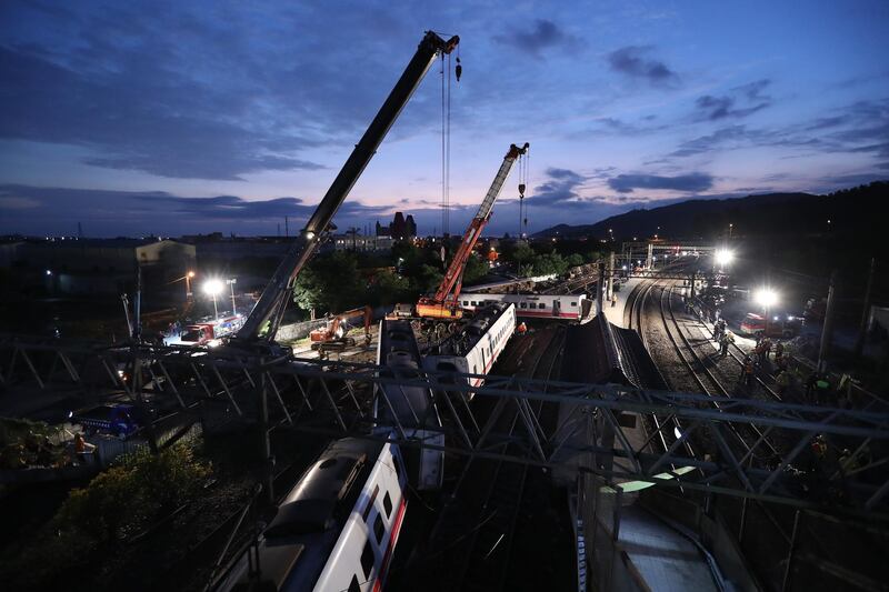 epa07110313 Rescuers uses crane to remove the derailed train on the site of accident in Yilan, Taiwan, early 22 October 2018. According to reports, at least 18 people died and about 160 are injured after a train carrying 366 people derailed and overturned on 21 October.  EPA/RITCHIE B. TONGO