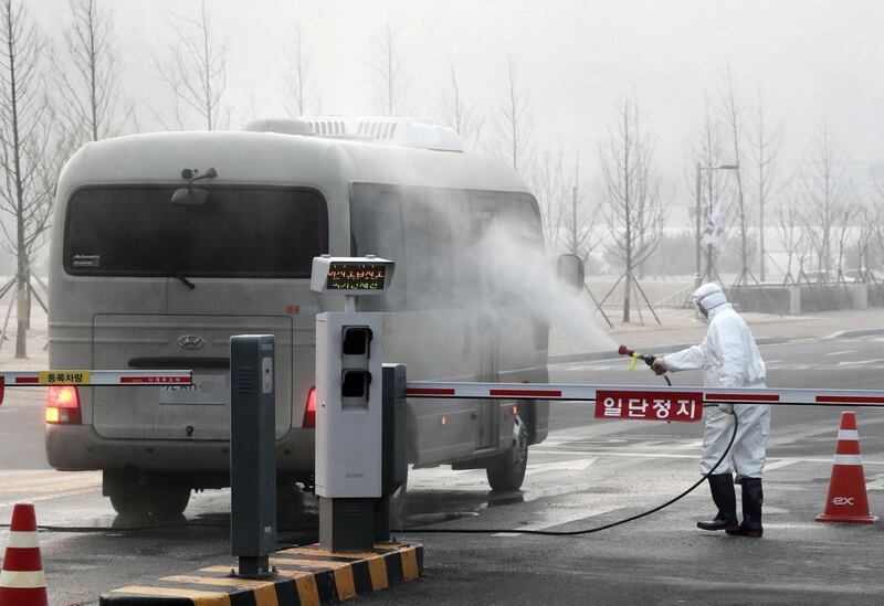 A quarantine worker disinfects a bus entering the National Human Resources Development Centre in Jincheon, South Korea.  EPA
