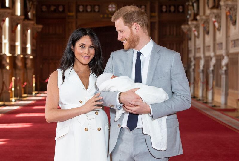 Britain's Prince Harry, Duke of Sussex (R), and his wife Meghan, Duchess of Sussex, pose for a photo with their newborn baby son in St George's Hall at Windsor Castle in Windsor, west of London on May 8, 2019. / AFP / POOL / Dominic Lipinski
