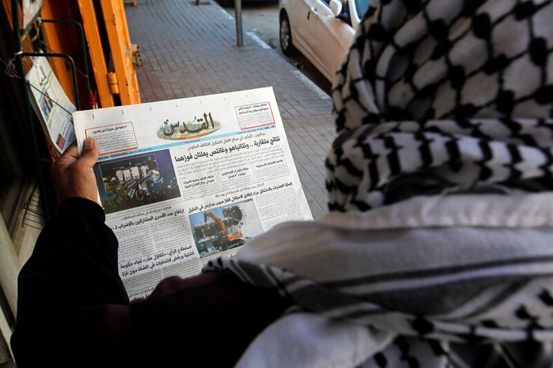 A Palestinian man reads a local newspaper with news of the Israeli election, in Hebron, in the Israeli-occupied West Bank April 10, 2019. REUTERS/Mussa Qawasma