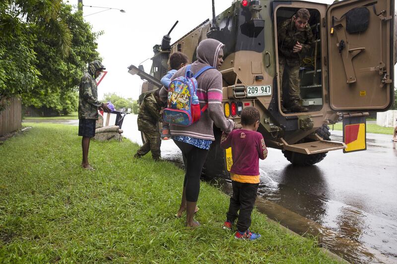 Army personnel assist a family being evacuated from rising flood waters in Rosslea.  EPA