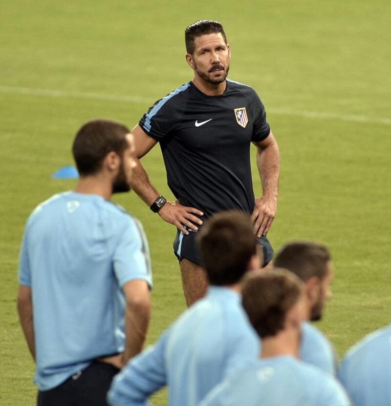 Atletico Madrid coach Diego Simeone, centre, has successfully transitioned his philosophy of defence first to the team. Diego Forlan says the triumphs have changed the club’s mindset. Louisa Gouliamaki / AFP