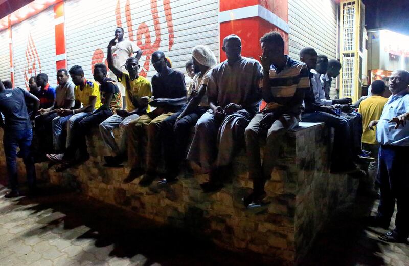 Civilians sit on a wall near the area where gunmen opened fire outside buildings used by Sudan's National Intelligence and Security Service (NISS) in Khartoum, Sudan January 14, 2020. REUTERS/Mohamed Nureldin Abdallah