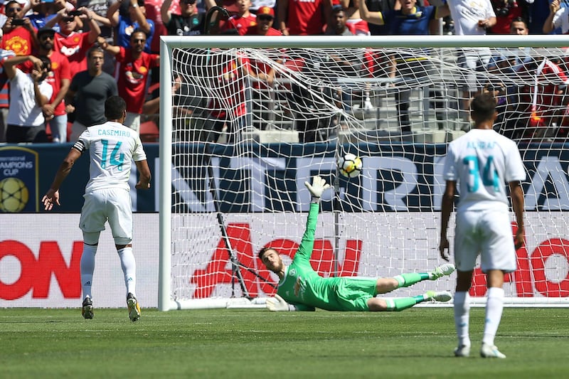 Real Madrid midfielder Casemiro, left, scores from the penalty spot. Beck Diefenbach / AFP