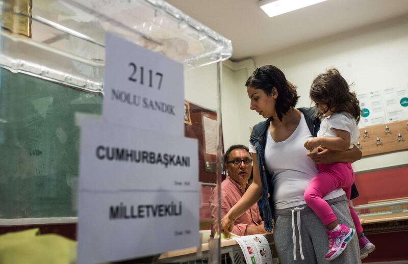 A woman picks up a ballot at a polling station in Istanbul, Turkey, on June 24, 2018. Yasin Akgul / AFP