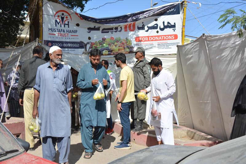 People collect fresh produce from the Ramadan relief fruit stall