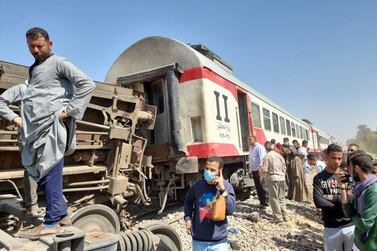 People inspect the scene of a train crash in Egypt's Sohag province on March 26, 2021. EPA