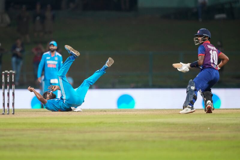 India's Hardik Pandya loses his balance after delivering a ball as Nepal's Sompal Kami watches. AP