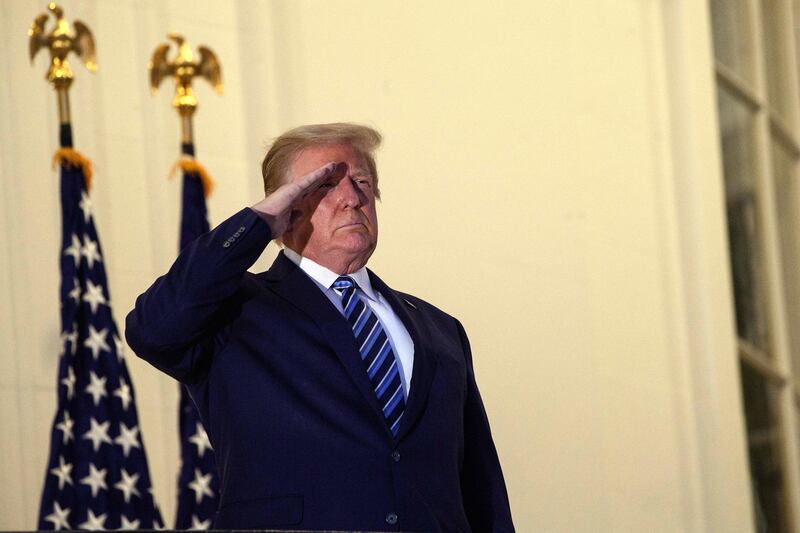 US President Donald Trump salutes from the Truman Balcony upon his return to the White House from Walter Reed Medical Center, where he underwent treatment for Covid-19, in Washington, DC, on October 5, 2020. (Photo by NICHOLAS KAMM / AFP)