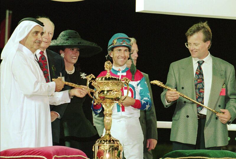 Prime minister of the UAE and ruler of Dubai Sheikh Maktoum Bin Rashid Al Maktoum, left, hands the Dubai World Cup trophy to jockey Jerry Bailey of the race horse Cigar of the United States Wednesday, March 27, 1996 at the Nad Al Sheba race track in Dubai, United Arab Emirates. Cigar turned back a strong challenge from Soul of the Matter in the final furlong and won his 14th straight race, capturing the US $4 million award. Cigar's owner Allen Paulson stands at right. (AP Photo/B.K. Bangash)