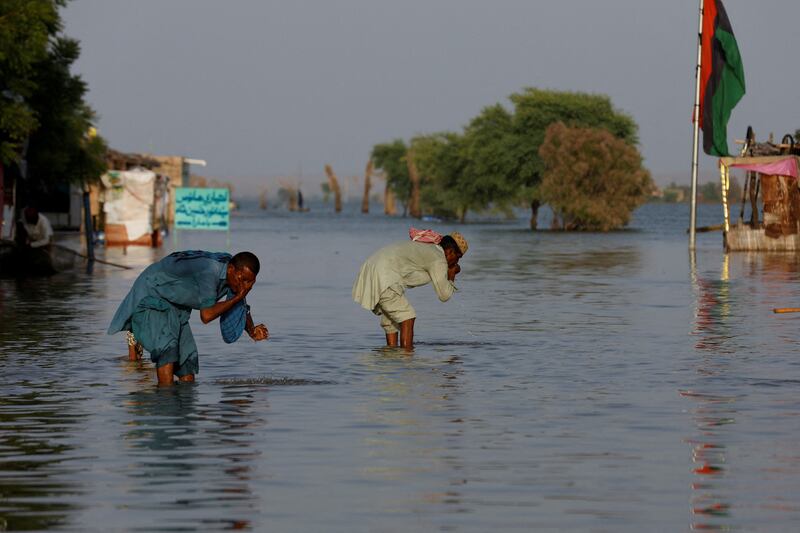 Men perform ablution with the flood water in Bajara village, at the banks of Manchar Lake, Sehwan. Reuters