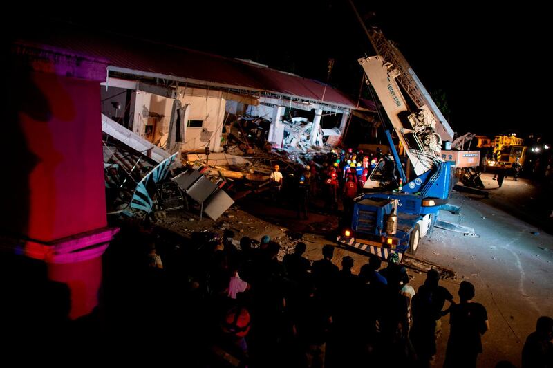 Rescue workers search for survivors in a collapsed Chuzon Super Market in Porac, Pampanga. AFP