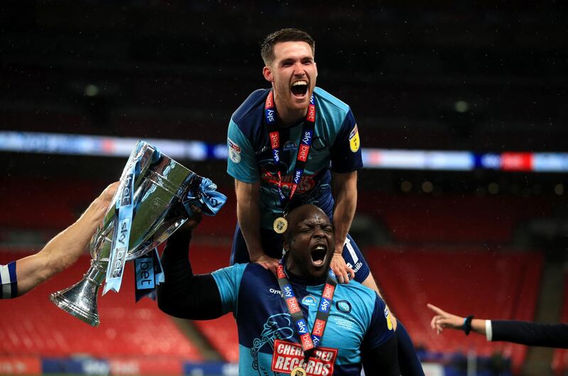 Wycombe Wanderers' Adebayo Akinfenwa (bottom) celebrates with the trophy after winning the League One play-off final at Wembley Stadium. PA