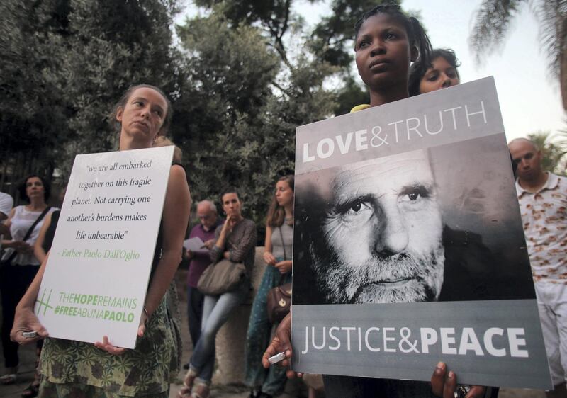 Women hold placards during a vigil in solidarity with Italian Jesuit priest Father Paolo Dall'Oglio and the Syrian people on July 29, 2015 in front of the Jesuit Church in the Lebanese capital Beirut. Father Paolo Dall'Oglio disappeared on July 29, 2013 in the northern Syrian city of Raqqa, where he went to negotiate with jihadists.  AFP PHOTO / STR / AFP PHOTO / -