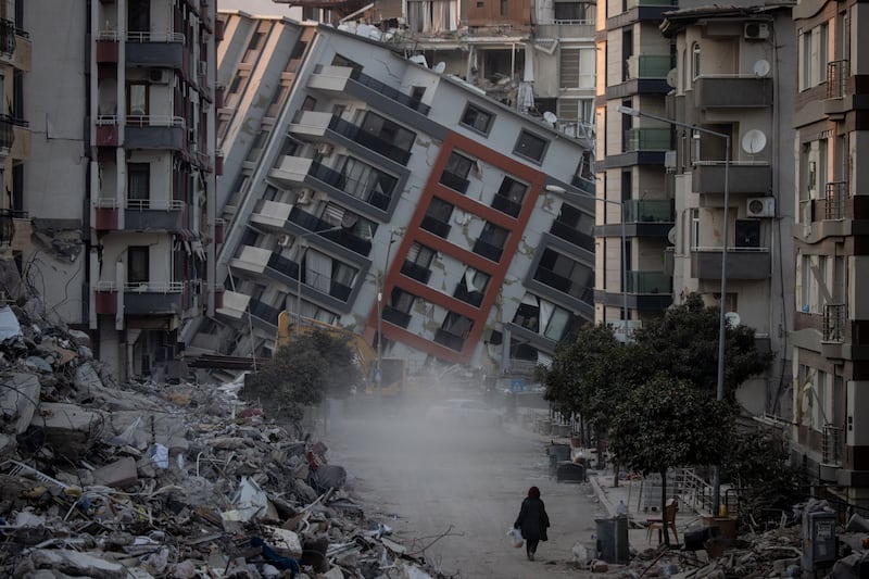 A woman walks among destroyed buildings in Hatay, Turkey. Getty Images