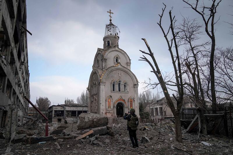 A Ukrainian serviceman near a damaged church after shelling in a residential district of Mariupol. AP