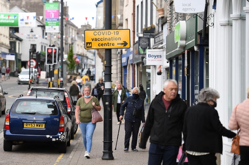 Members of the public walk past shops in Kendal in Cumbria, where surge testing has been deployed following an outbreak of a coronavirus variant of concern. AFP