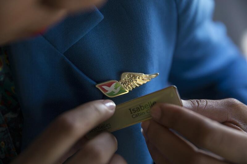 An Air Seychelles fly attendant adjusts her name pin. In 2012, Etihad took a 40 per cent stake in Air Seychelles in a deal worth $45m. The airline has since turned a profit for two consecutive years. Silvia Razgova / The National