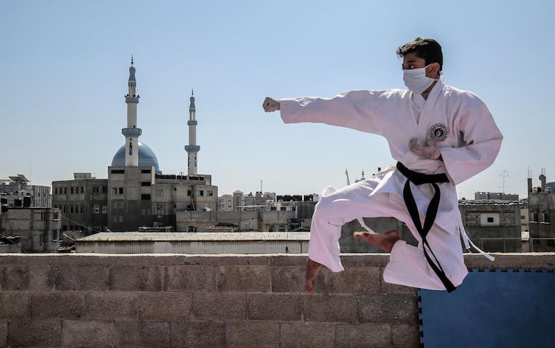 Wael, one of the sons of Palestinian Karate coach Khaled Sheikh Eid, trains on the rooftop of his family house at a refugee camp in Rafah in the Gaza Strip.    AFP