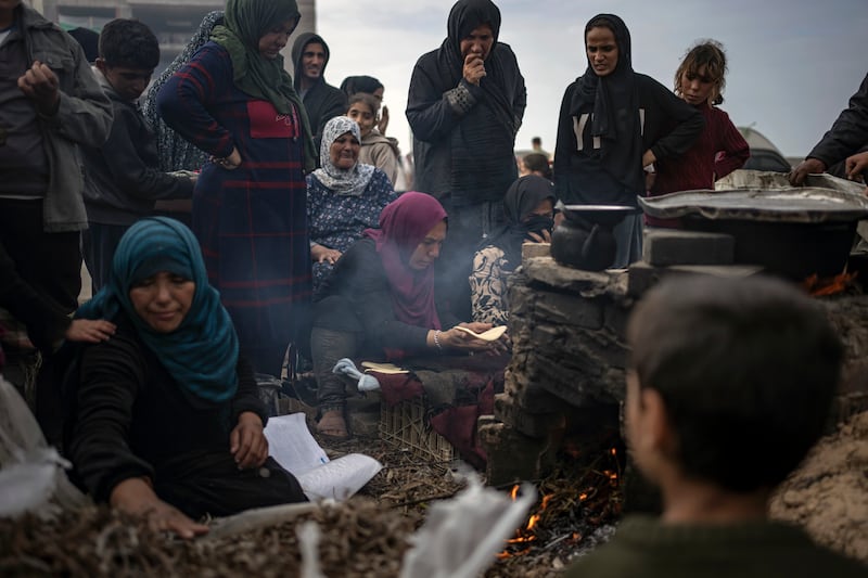 Displaced Palestinians queue to bake bread at a camp in the Muwasi area of Rafah, Gaza Strip, on December 23, 2023. AP Photo