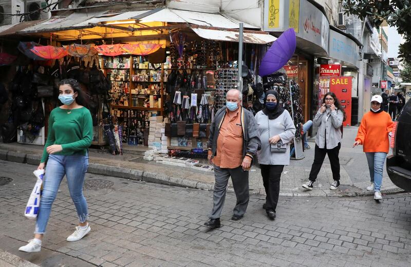 People wearing face masks walk past a shop after its reopening, as the coronavirus disease (COVID-19) restrictions are eased, in Beirut, Lebanon. Reuters