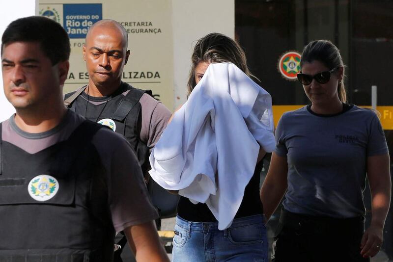 Francoise Souza Oliveira, 40, wife of Kyriakos Amiridis, the murdered Greek Ambassador to Brazil, is escorted by police officers as she is transferred from a police station to a jail in Belford Roxo, Brazil on December 31, 2016. Marcos de Paula / Reuters 