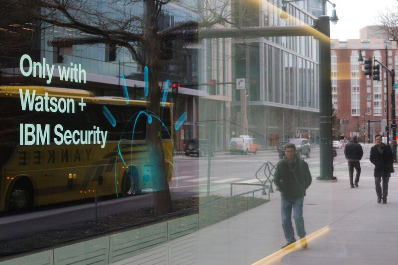 Pedestrians pass a video advertisement for IBM at their office in Cambridge, Massachusetts, U.S., January 16, 2018.   REUTERS/Brian Snyder