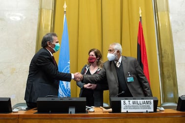 Head of the Libyan Arab Armed Forces delegation Amhimmid Alamami, left, and Head of the Government of National Accord’s (GNA) military delegation Ahmed Ali Abushahma shake hands next to deputy special representative of the UN Secretary-General for Political Affairs in Libya Stephanie Williams in Geneva.  Violaine Martin / UN / AFP