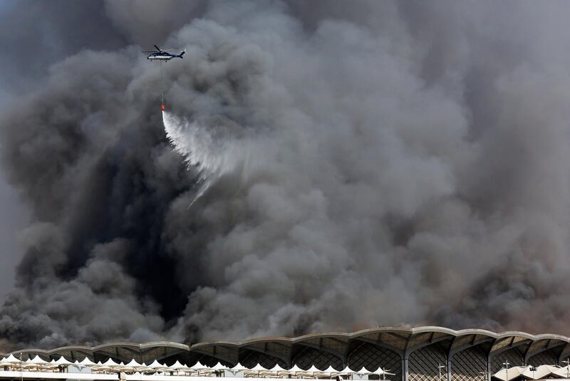 A firefighting helicopter sprays water on the fire in Jeddah. AP Photo
