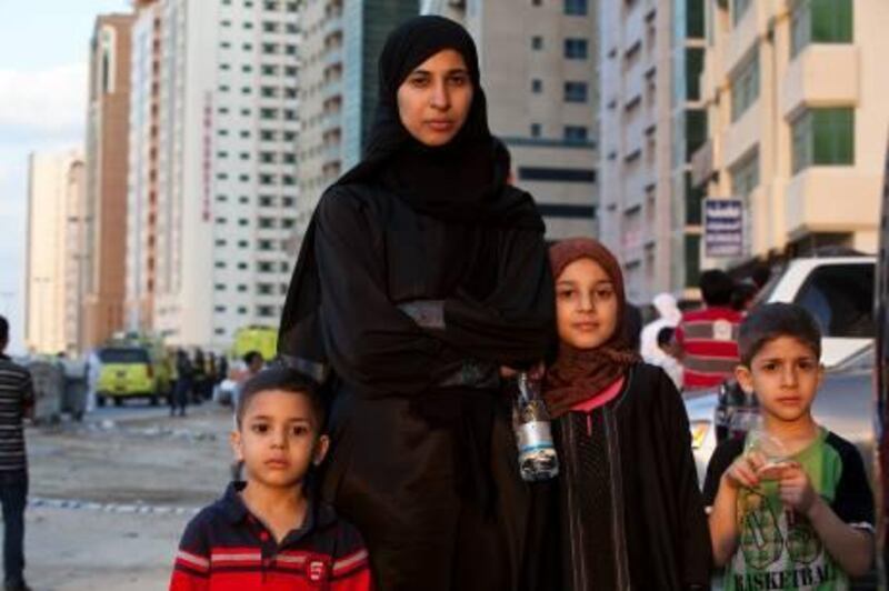 November 08. Residents Sana Badawi and her childern (LtoR) Abdullah, Lian and Ismail wait in the street while fire fighters extinguish a fire in their residential tower in the Al Nahda area in Sharjah. November 08, Dubai, United Arab Emirates (Photo: Antonie Robertson/The National)
