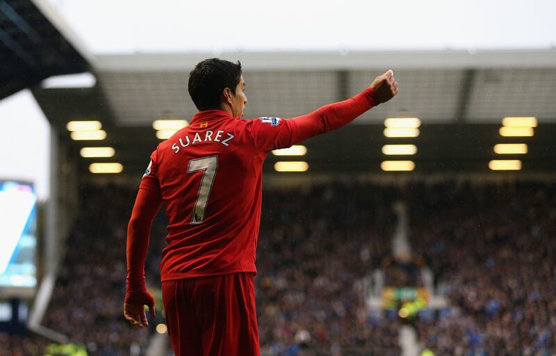 LIVERPOOL, ENGLAND - OCTOBER 28:   Luis Suarez of Liverpool holds up a coin thrown from the crowd during the Barclays Premier League match between Everton and Liverpool at Goodison Park on October 28, 2012 in Liverpool, England.  (Photo by Clive Brunskill/Getty Images) *** Local Caption ***  154871515.jpg