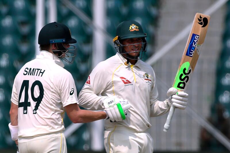 Australia's Usman Khawaja, right, celebrates after completing his fifty on the first day of the third Test in Lahore. AP